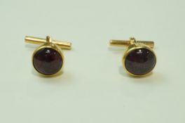 A pair of cabochon star ruby cufflinks, stamped '18ct', the cabochons of approximately 11.