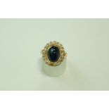 A cabochon sapphire and diamond 18 carat gold cluster ring, the nineteen diamonds,
