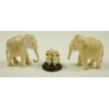 Two early 20th century carved ivory elephants and along with three carved monkeys on a wooden base
