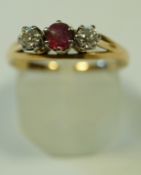 A ruby and diamond three stone ring, stamped '18ct',