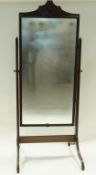 A mahogany framed cheval mirror with carved crest, frame and outswept legs, 180cm high, 77.