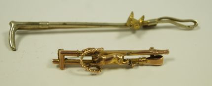A brooch in the form of two hunting crops and a hound,