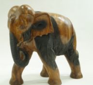 A large Indian carved wood figure of an elephant with trunk curled, overall 70cm high,