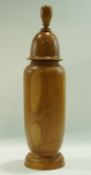 A turned walnut jar and cover with a turned finial,