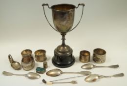 A silver napkin ring; with three others; a German silver coloured napkin ring; a silver trophy cup,