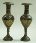 A pair of Middle Eastern brass and silvered vases decorated with flowers,