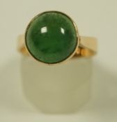 A nephrite ring, the cabochon to a mount stamped '9ct', finger size N, 4.