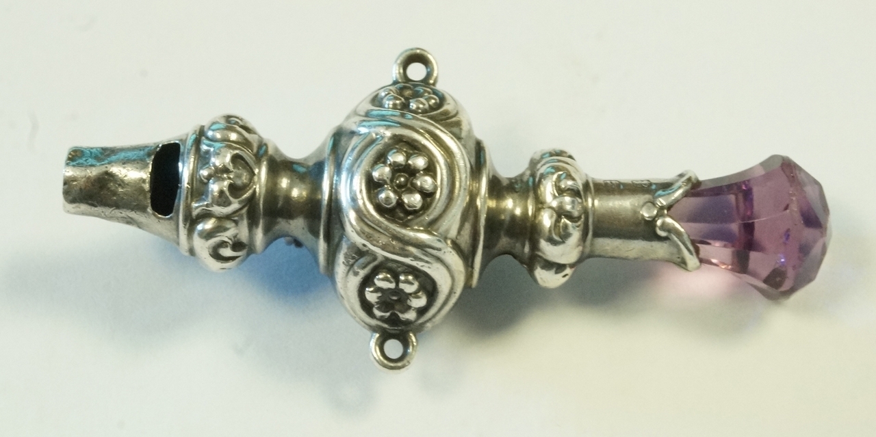 A silver whistle, Birmingham 1907, with a paste set finial,