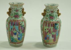 A pair of Canton enamel two handled vases painted with figures on a flower and butterfly ground,