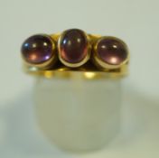 A three stone cabochon ring, stamped '18ct', finger size R, 5.