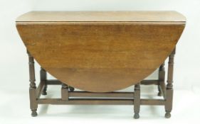 An oak drop leaf table with turned legs linked by rectangular stretchers, 75cm high, 128.