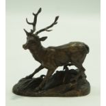 A bronze figure of a stag on a naturalistic rocky base,
