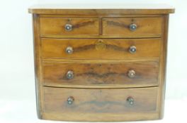 A Victorian mahogany bow fronted chest of two short and three long drawers with turned handles,