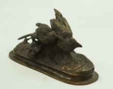 A bronze figure of two birds on a rectangular base with rounded ends