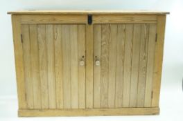 A pine cupboard with hinged top above two doors with turned handles on plinth base. 109cm high, 152.