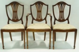 A set of six mahogany dining chairs, the shield backs carved with a wheat sheaf and pierced splat,