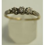 A three stone diamond ring, illusion set with graduated brilliant and single cuts, finger size S, 2.