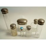 A collection of seven silver topped toilet bottles,