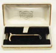 A two colour brooch, in the form of a riding crop, stamped 'J.G. & S 9ct', 5.8 cm long, 4.