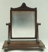 A Victorian mahogany swing frame dressing table mirror with carved crest and bun feet, 58.