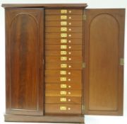 A Victorian mahogany collectors cabinet with two arched panelled doors enclosing thirty two drawers