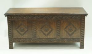 An oak coffer with carved triple panel front, 55cm high, 122cm wide, 45.