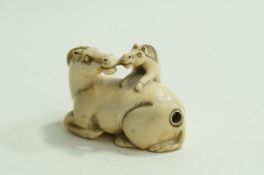An early 20th century carved ivory netsuke of horse and foal