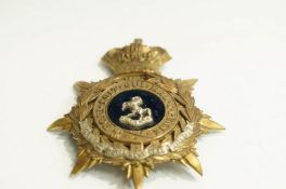 A brass and white metal helmet plate to the Royal West Regiment.