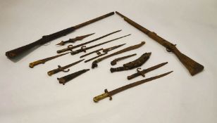 A collection of 19th and 20th Century Military items, including bayonets, flintlock rifles,