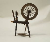 A 19th Century ash and oak spinning wheel with remains of paintwork, including a figure.