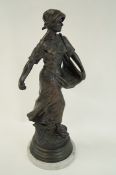 A large 20th Century bronze of a lady sowing seeds, with signature to the base,