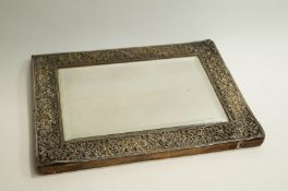 An early 20th Century Silver plated mounted mirror, with flower and berry border to bevelled mirror,