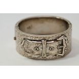 A silver hinged bangle, Birmingham 1936, in the Victorian style of a buckle to an engraved ground,