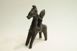A Persian patinated metal figure of a man on horseback,