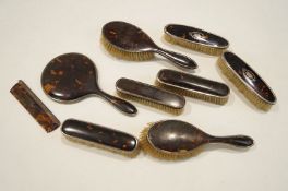 Eight silver and tortoiseshell mounted dressing table items, to include a round hand mirror,