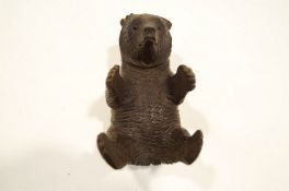 A carved Black Forest bear, modelled lying on his back.