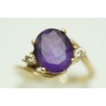 An amethyst and diamond three stone ring, stamped '9K',