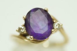 An amethyst and diamond three stone ring, stamped '9K',
