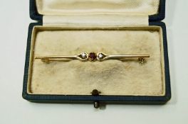 A 9 carat gold ruby and diamond three stone bar brooch, 5.6 cm long, 1.