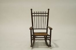 A 19th Century oak and ash child's rocking armchair, with turned uprights and woven seat,
