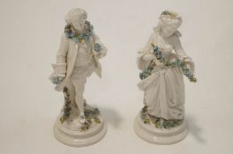 A pair of late 19th Century/early 20th Century Sitzendorf figures of a male and female, 26cm wide.