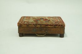 A Victorian rosewood footstool with turkey carpet covered top opening to reveal a copper hot water