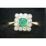 An emerald and diamond cluster ring, stamped '18ct',