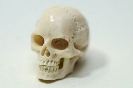 A 20th Century miniature carved skull, in bone, 2.