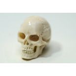 A 20th Century miniature carved skull, in bone, 2.