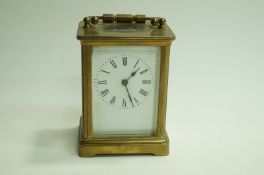 A 20th Century French carriage clock, with a white enamel face and black roman numerals, 10.