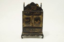 An early 20th Century Chinese black lacquer table top cabinet with nine fitted drawers,