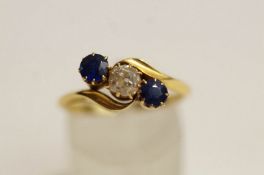 A sapphire and diamond three stone cross-over 18 carat gold ring,