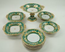A 19th Century pottery dessert service decorated with scrolls in yellow and gilt on a green ground,