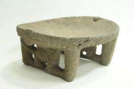 A Costa Rican stone Metate Pre-Columbian, with concave platform above two pierced legs,